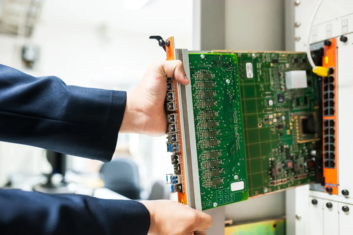 Technician installing an electronic control module in a machine
